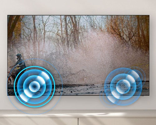 A person on a motorcycle is zipping past from one side to another. Built-in speakers follow the sound of the motorcycle as it moves.