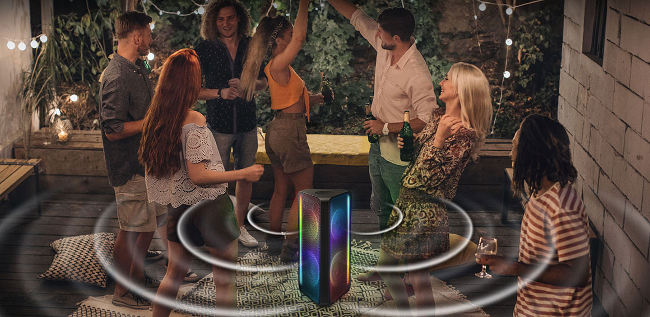 7 people are at an outdoor area having a party with a Sound Tower in the middle, which is sending out sound bi-directionally.